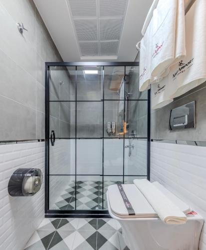 a bathroom with a glass shower and a toilet at Atar Airport Hotel - Spa & Wellness in Arnavutköy