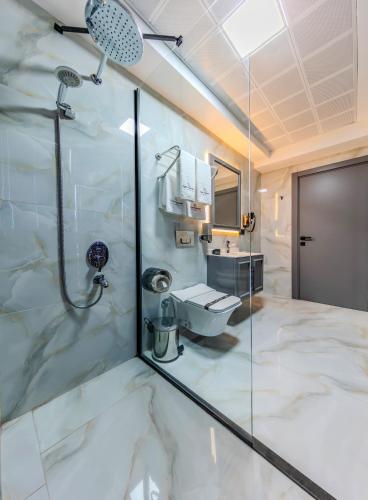 a bathroom with a shower and a toilet at Atar Airport Hotel - Spa & Wellness in Arnavutköy