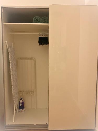a white cupboard with a shelf in a room at Panoramameerblicksuite direkt am Strand, Garage Wlan, Aufzug, Smarttv,Bettwäsche,Handtücher, Netflix uvm in Cuxhaven