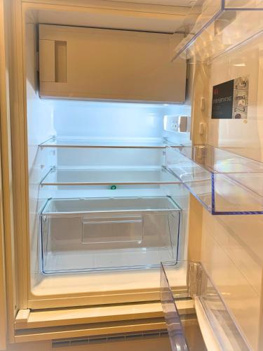 an empty refrigerator with its door open with its at Panoramameerblicksuite direkt am Strand, Garage Wlan, Aufzug, Smarttv,Bettwäsche,Handtücher, Netflix uvm in Cuxhaven