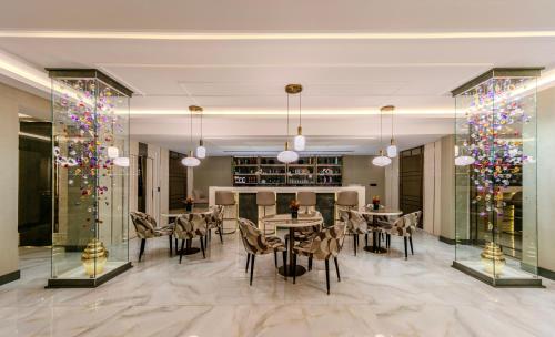 a dining room with tables and chairs and christmas trees at Atar Airport Hotel - Spa & Wellness in Arnavutköy