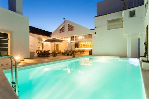 a swimming pool in front of a house at Ericeira Soul Guesthouse in Ericeira