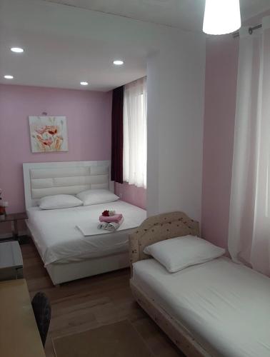two beds in a room with pink walls at Riian Luxury Apartments in Ulcinj