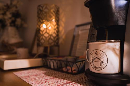 a coffee maker sitting on a table next to a coffee cup at Coppermoon Cabin in Broken Bow