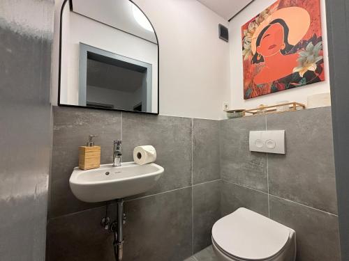 a bathroom with a sink and a toilet and a mirror at 200qm - 9 rooms - Parkplatz - 3 Bäder - MalliBase Apartments in Garbsen