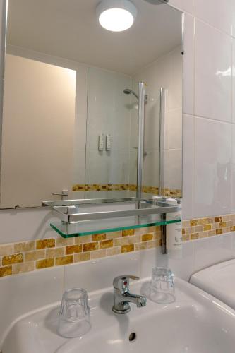 a bathroom with a sink and a mirror at Gairloch Hotel 'A Bespoke Hotel' in Gairloch
