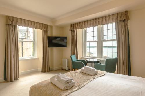 a bedroom with a bed with two towels on it at Gairloch Hotel 'A Bespoke Hotel' in Gairloch