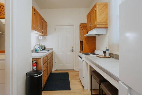 a kitchen with white counters and wooden cabinets at Oakdale Suites - Master Property in Medford