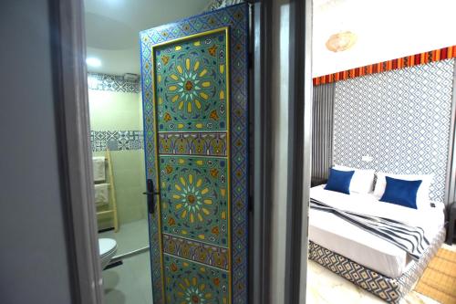 a room with a bedroom with a bed and a door at Maison Nomedia in Essaouira