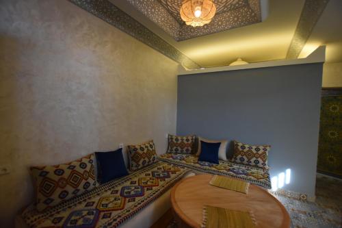 a room with a couch and a wooden table at Maison Nomedia in Essaouira