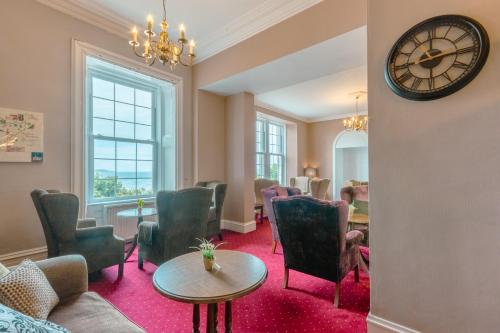 a waiting room with chairs and a clock on the wall at Gairloch Hotel 'A Bespoke Hotel' in Gairloch