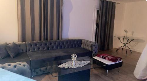 un salon avec un canapé bleu et une table dans l'établissement Appartement avec jacuzzi, à Meudon