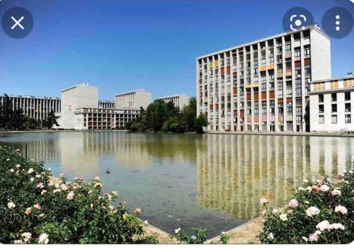 une grande masse d'eau devant un bâtiment dans l'établissement Appartement avec jacuzzi, à Meudon