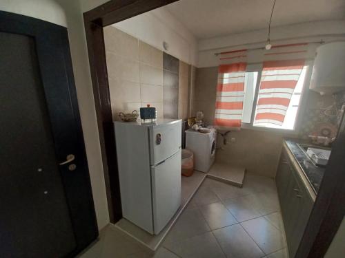 a small kitchen with a refrigerator and a sink at EXCELLENT rapport Qualité Prix pour cet Appartement 3 étoiles 2P Tout Confort Clim Reversible Résidence Golf Mesnana Tanger in Tangier