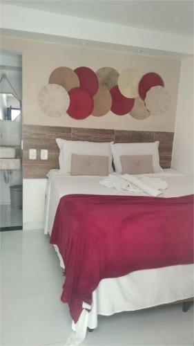 a bedroom with a large bed with a red blanket at Pousada Villa Goyá in São José da Coroa Grande