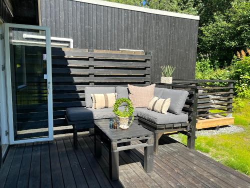 a patio with a couch and a table on a deck at Åre Travel - Villa Solbringen eller Lilla Sol in Åre