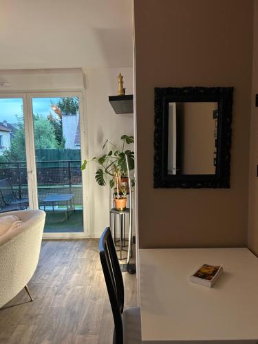- un salon avec un miroir et une table dans l'établissement Appartement PARIS-Le Plessis-Trévise, à Le Plessis-Trévise
