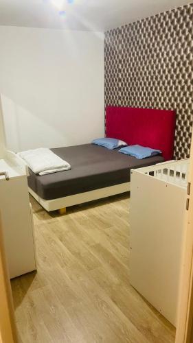 Cette petite chambre comprend un lit avec une tête de lit rouge. dans l'établissement Arena La defense nanterre prefecture, à Nanterre