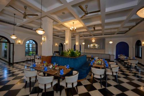 a restaurant with tables and chairs in a room at The Old Court House By Abad in Cochin