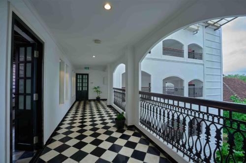 a hallway of a house with a checkered floor at The Old Court House By Abad in Cochin