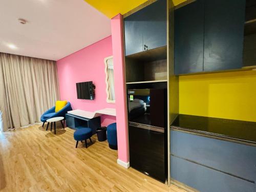 a room with a desk and chairs and a cabinet at FLAMINGO Ibiza HaiTien - Ivy Abtel in Thanh Hóa