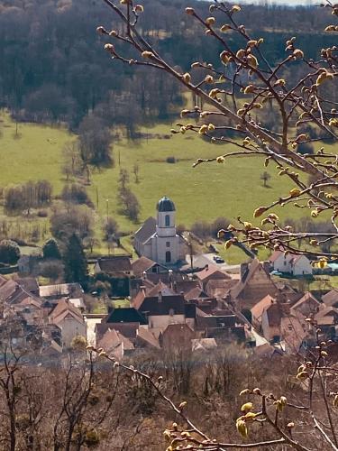 a small village with a church in a field at L’ Annexe in Chariez