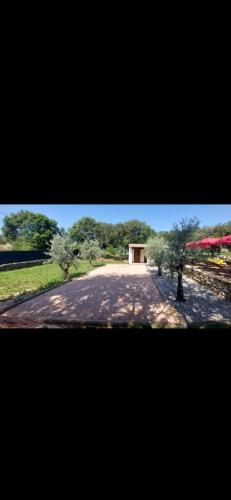 un chemin de terre avec un bâtiment au loin dans l'établissement Maison à louer, à Néoules