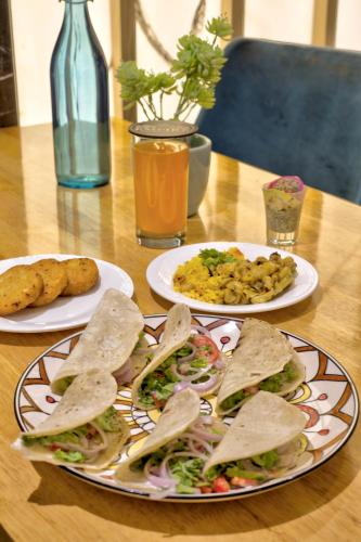 three plates of food on a wooden table at Empire Platinum Suites in New Delhi