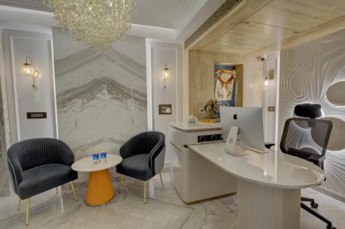 a room with chairs and a desk with a computer on it at Empire Platinum Suites in New Delhi