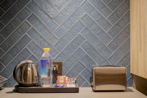 a counter with a toaster and a bottle of water at Empire Platinum Suites in New Delhi