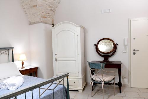 a bedroom with a bed and a mirror and a chair at Casa Masaniello in Martina Franca