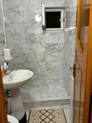 a white bathroom with a sink and a shower at David și Daria in Vaslui