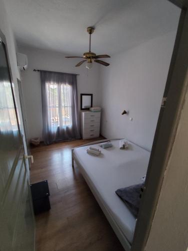 a bedroom with a bed and a ceiling fan at Garden Roses in Benitses