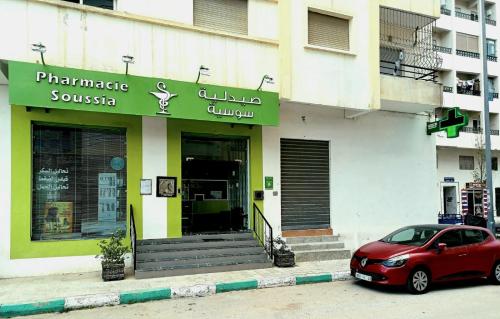 a red car parked in front of a building at EXCELLENT rapport Qualité Prix pour cet Appartement 3 étoiles 2P Tout Confort Clim Reversible Résidence Golf Mesnana Tanger in Tangier
