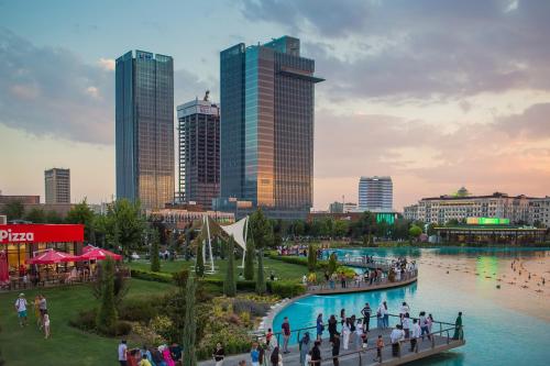 a group of people walking on a bridge over a river at 6E, 142, 91m2, Tashkent City Park, Gardens Residence in Tashkent