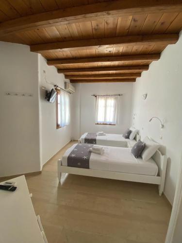 a bedroom with a bed and a wooden ceiling at Fisilanis Beachfront Hotel in Logaras