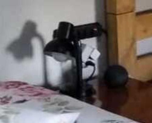 a black lamp sitting on top of a table at Pousada Seu Jorge in Campinas