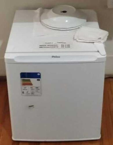 a white washing machine sitting on top of a refrigerator at Pousada Seu Jorge in Campinas