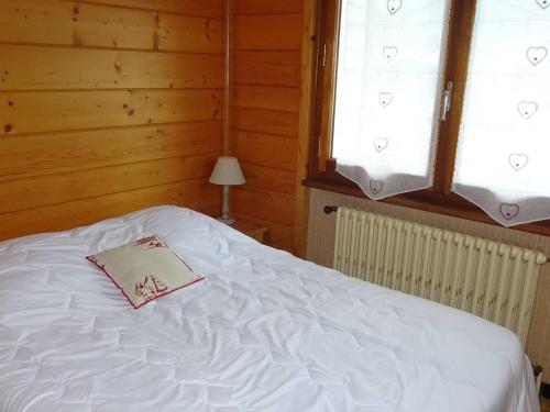 - un lit avec un livre dans une chambre dans l'établissement Appartement 2 pièces pour 4, proche pistes et commerces, Les Gets, WiFi, parking, lave-linge - FR-1-802-48, aux Gets