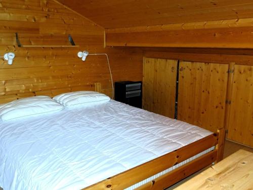 une chambre avec un lit dans une cabane en bois dans l'établissement Chalet Les Gets 10 pers - Garage - WIFI - Proche centre - FR-1-802-69, aux Gets