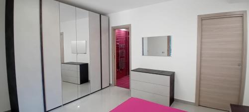 a hallway with a mirror and a red door at B&B Carpe Diem Domus in Lacco Ameno