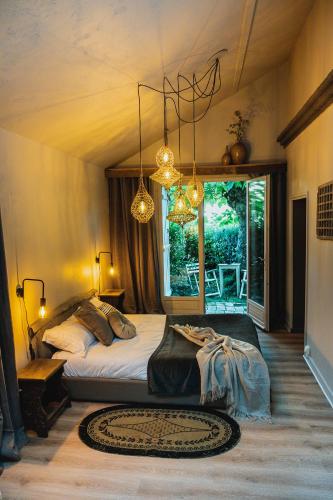 une chambre avec un lit et une grande fenêtre dans l'établissement Le Clos du Lavoir Sancerre, à Neuilly-en-Sancerre