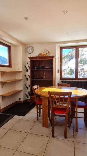 une salle à manger avec une table et des chaises en bois dans l'établissement Appartement La Duchère Le Plan-la Giettaz massif des Aravis, à La Giettaz