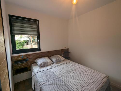 une petite chambre avec un lit et une fenêtre dans l'établissement Le Cabanon T1 à Quissac, résidence avec piscine, à Quissac