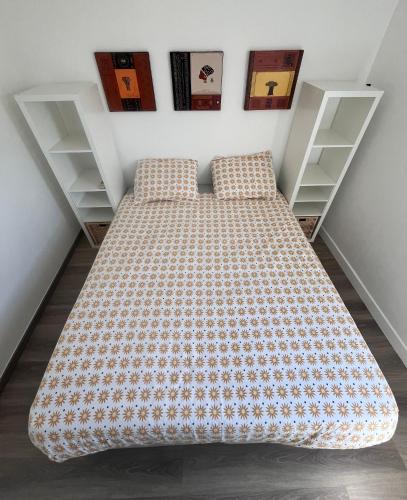 un lit avec des oreillers dans une pièce avec des étagères dans l'établissement L'appart D79, à Gruissan