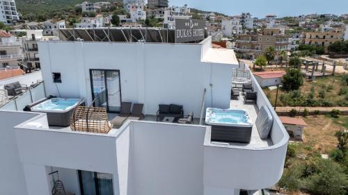 a white building with two hot tubs on the roof at Duka's Hotel in Ksamil