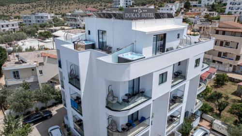 a white building with a sign on it at Duka's Hotel in Ksamil
