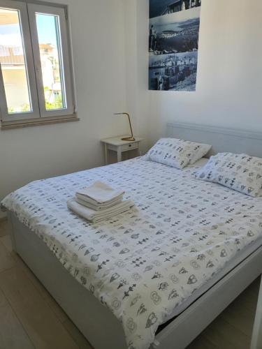 Un dormitorio con una cama con un edredón blanco. en Villa Sisa Apartment, en Primošten