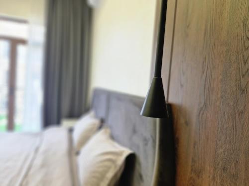 a black lamp next to a bed in a room at 5, 37, 65m2, Tashkent City Park, Boulevard in Tashkent