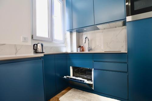 - une cuisine bleue avec un évier et des armoires bleues dans l'établissement Appartement cosy CANNES, à Cannes